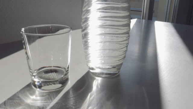 Volle-Wasserflasche,-leeren-Becher-und-Sonnenschein