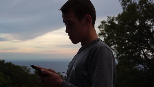 Silhouette-eines-Teenagers-mit-einem-smartphone