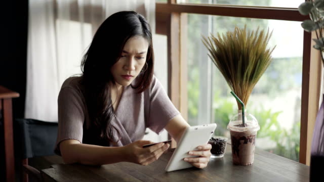 betonte-Frau-mit-Kreditkarte-Problem,-Online-shopping-mit-Tablet-im-café