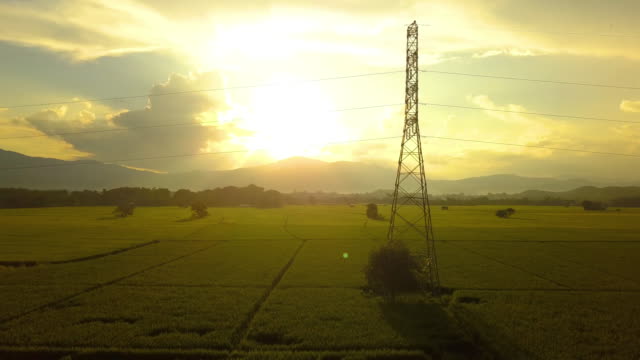 Flying-up-and-around-the-tall-voltage-electricity-tower-with-sundown