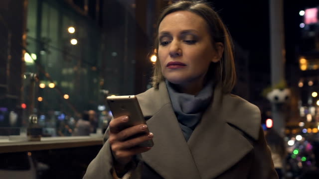 Elegante-junge-Dame-lesen-Nachricht-auf-Smartphone-während-des-Gehens-auf-Stadtstraße