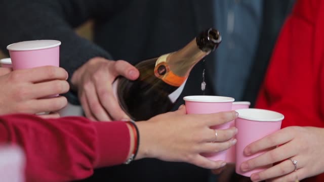 Smiling-people-pouring-champagne-during-fantastic-birthday-celebration,-spending-nice-time-together-at-the-weekend,-slowmotion-in-beautiful-studio-apartment