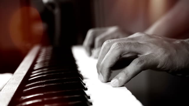 4K-footage-of-music-pianist-hands-playing-piano-at-the-night-club-with-spotlight-and-light-leak-bokeh.-musical-instrument-grand-piano-selective-focus-with-depth-of-field