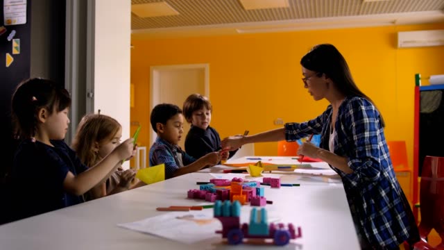 Multi-étnica-a-los-niños-crear-origami-en-clase-de-arte