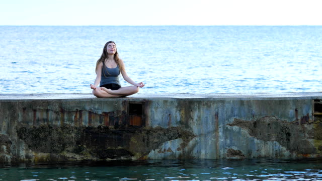 Adolescente-practicando-yoga-en-la-playa