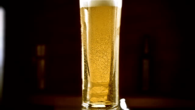 Close-up-slow-motion-Cold-Light-Beer-in-a-glass-with-water-drops-on-bar-background.-Craft-Beer-close-up
