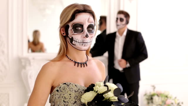 Girl-with-a-terrible-make-up-in-the-form-of-a-skull-in-a-room-with-a-man-in-suit