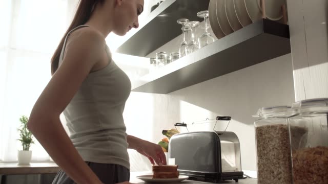 Frau,-die-Toasts-auf-Frühstück-modernen-leichten-Küche-kochen