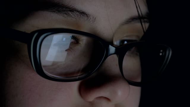 Mujer-utiliza-una-tableta-en-la-noche-la-pantalla-de-la-que-se-refleja-en-las-gafas