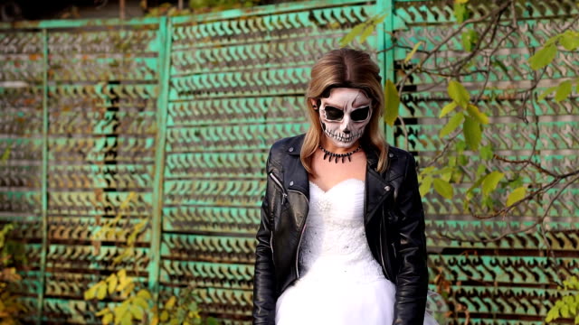 Girl-with-a-creepy-make-up-for-Halloween-on-the-background-of-an-old-rusty-fence