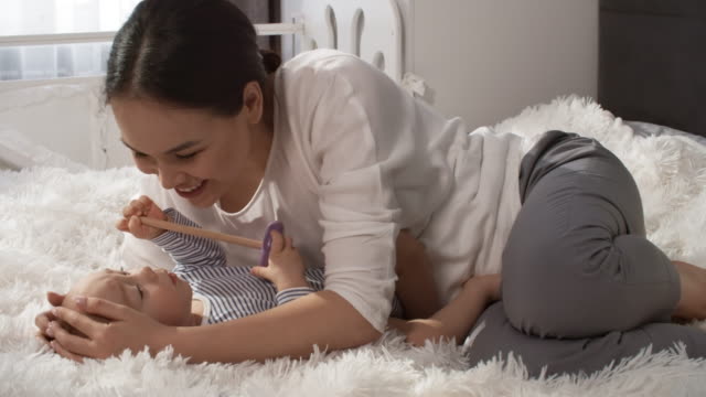 Affectionate-asiatische-Mutter-Streicheln-und-Küssen-Baby