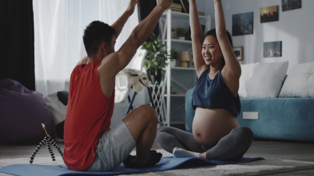 Young-man-instructing-pregnant-woman-during-workout