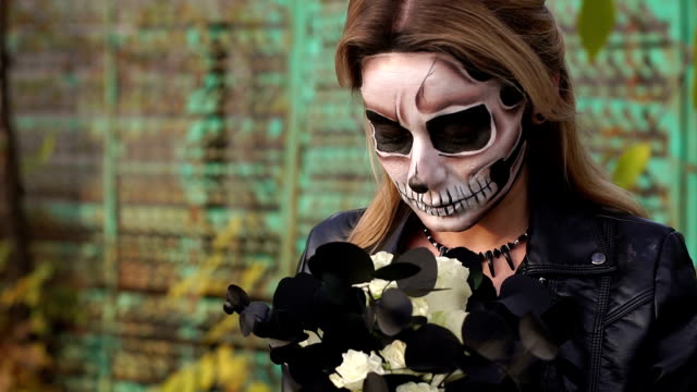 Creepy-bride-with-a-bouquet-of-black-flowers-and-make-up-in-the-form-of-a-skull.