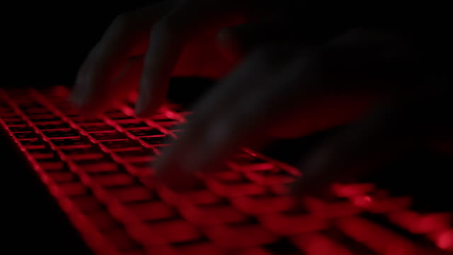 Programmer-typing-code-on-laptop-at-night