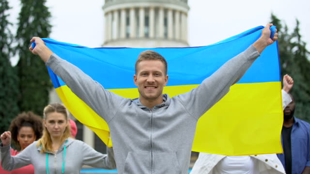 Happy-youth-raising-Ukrainian-flag,-diaspora-in-Washington,-patriotic-nation
