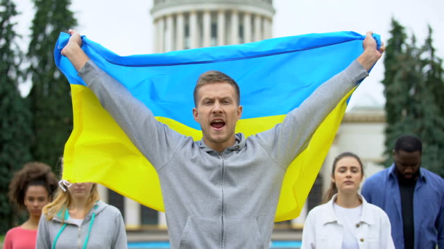 Aktivisten,-die-ukrainische-Flagge-hissen,-die-Slogan,-Unabhängigkeitskundgebung,-Patriotismus