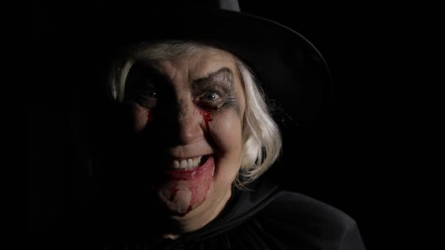Alte-Hexe-Halloween-Make-up.-Ältere-Frau-Porträt-mit-Blut-auf-ihrem-Gesicht.