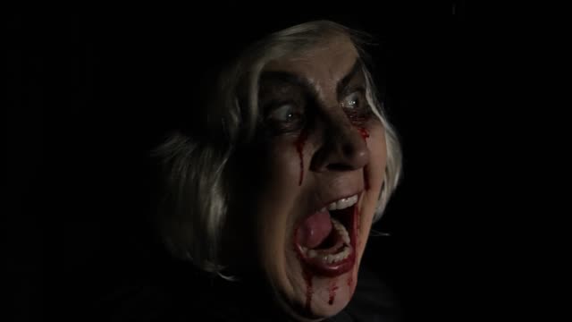 Old-witch-Halloween-makeup.-Elderly-woman-portrait-with-blood-on-her-face.