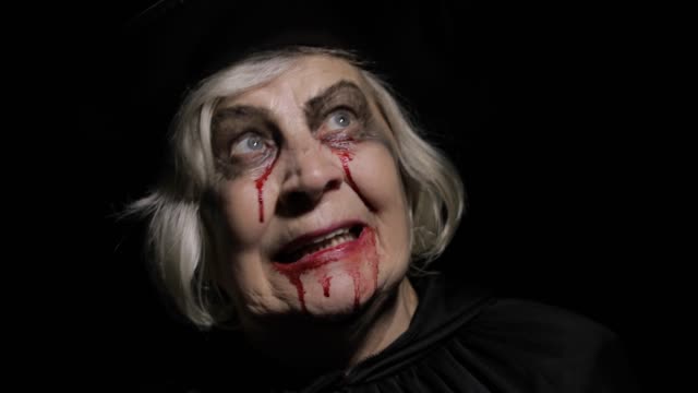 Alte-Hexe-Halloween-Make-up.-Ältere-Frau-Porträt-mit-Blut-auf-ihrem-Gesicht.