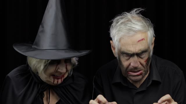 Elderly-man-and-woman-in-Halloween-costumes.-Witch-and-zombie