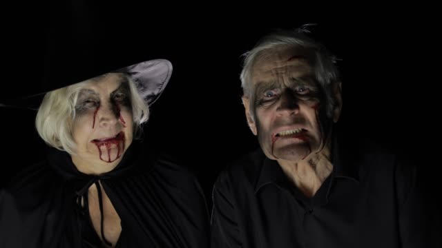 Elderly-man-and-woman-in-Halloween-costumes.-Dripping-blood-on-their-faces