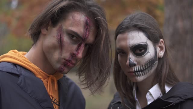 Tall-handsome-man-with-big-wound-on-his-face-and-pretty-girl-with-skull-makeup-standing-near