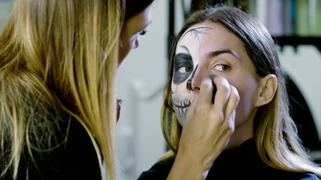 Make-up-artist-is-making-blonde-woman-up-as-dead-bride-for-Halloween-party.-4K