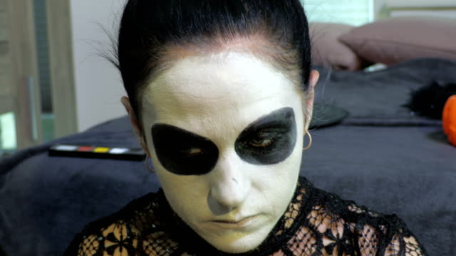 Woman-apply-Halloween-make-up.Halloween,Day-of-the-Dead--makeup-ideas-concept