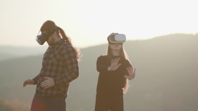Innovation-VR-technology-concept,-two-people-in-virtual-reality-box-glasses-gadget-technology-on-road-in-forest-on-hills-nature-background,-two-people-use-headset-digital-for-entertainment-experience