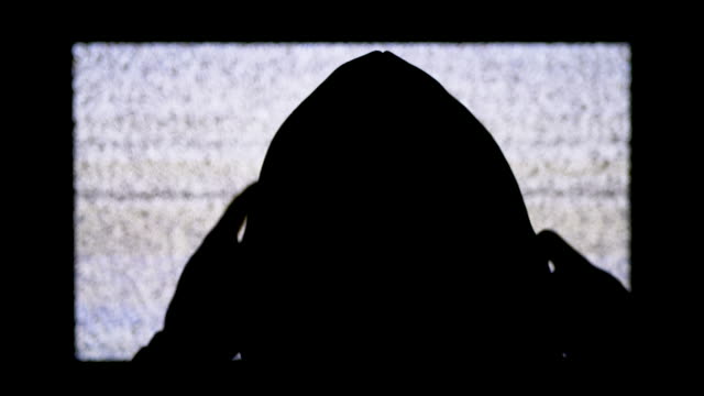 Silhouette-of-Man's-Head-in-Hood-is-Watching-White-Static-Noise-and-TV-Interference