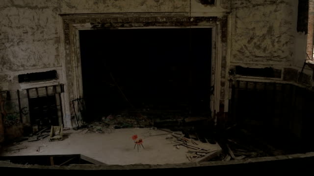 An-empty-chair-on-eerie-stage-in-abandoned-old-theatre-in-crumbling-cathedral