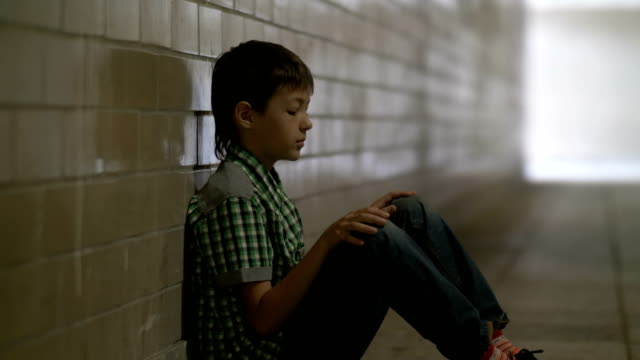 traurig,-einsam-misshandelte-Junge-sitzt-auf-dem-Boden-in-einem-Tunnel-in-Tiefe-Depression-schaut,-ist-niemand-für-den-jungen-zu-Hause-warten
