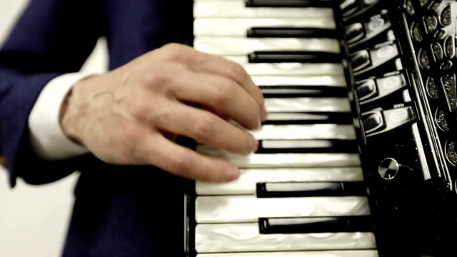 Close-up-of-a-man's-right-hand-playing-on-a-black-accordion.
