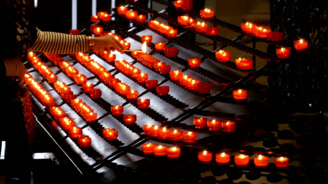 Woman-Puts-Candle-in-the-Christian-Church.-Many-Candles-Are-Lit-in-the-Temple