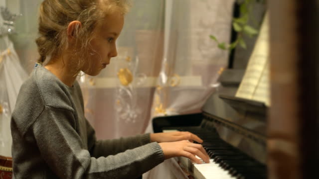 Pretty-little-girl-learns-to-play-the-piano.
