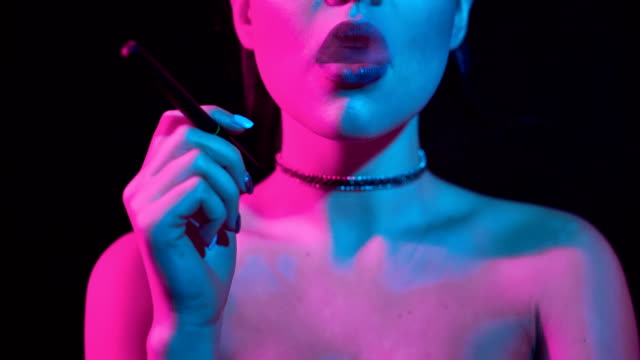 Wunderschöne-Brünette-Frau-rauchen-elektronische-Zigarette-in-Neon-Farbe-Licht