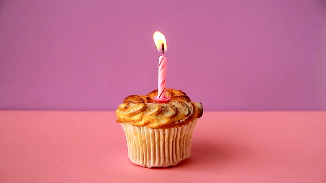 Cupcake-mit-einer-brennenden-Kerze-zum-Geburtstag