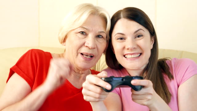 Mutter-und-Tochter-Gamer-spielen-Video-Spiel-zu-Hause.-Spieler-mit-Fernbedienung-Spielkonsole