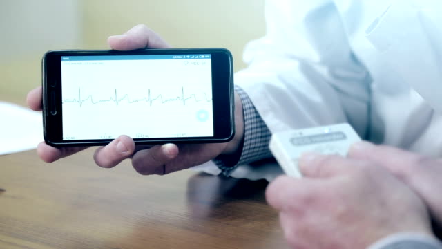 Ein-Arzt-zeigt-ein-EKG-auf-dem-Handy