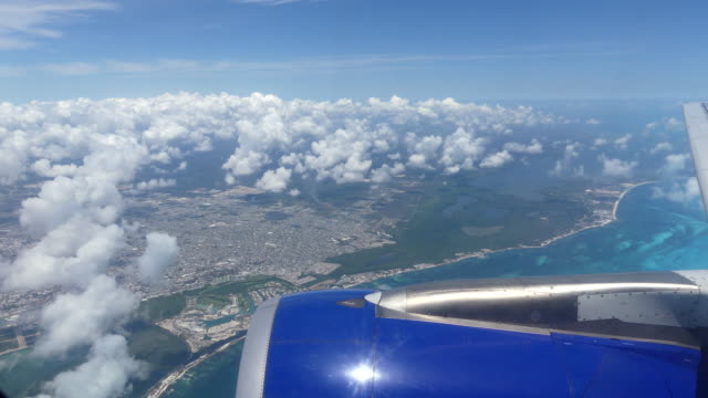 Airplane-flying-over-beautiful-blue-sea-Cancun-Mexico