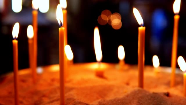 Burning-candles-inserted-in-the-sand-in-the-Orthodox-Church