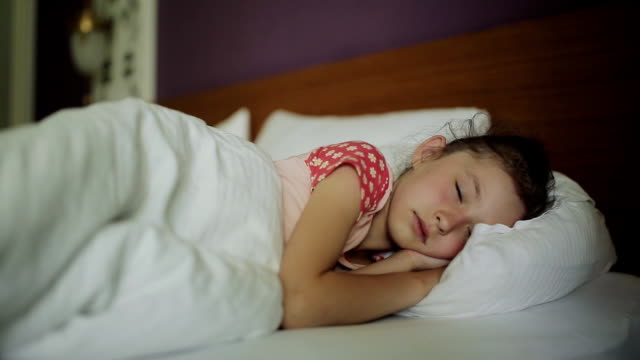 Woman-waking-young-girl-in-bed-smiling,-Mother-coming-to-the-sleeping-child