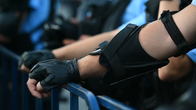 Polizist-die-Hände-auf-einen-Sicherheitszaun-während-eines-Aufstandes