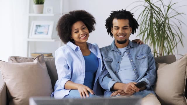 happy-smiling-couple-watching-tv-at-home