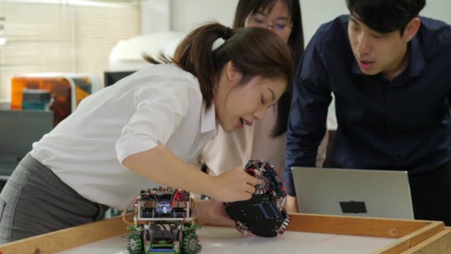Equipo-de-Ingeniero-robótica-trabaja-con-robot,-montaje-y-pruebas-respuestas-robótica-con-laptop-computadora-en-taller.-Personas-con-el-concepto-de-tecnología-o-innovación.