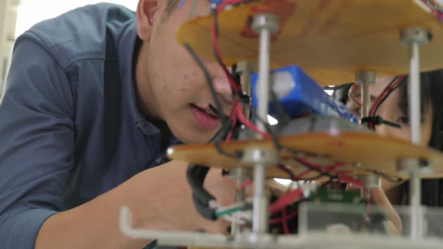 Electrónica-jóvenes-asiático-Ingeniero-robótica-construcción-y-fijación-en-el-laboratorio.-Personas-con-el-concepto-de-tecnología-o-innovación.