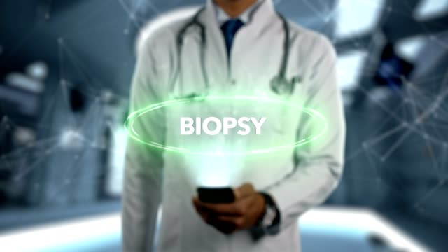 BIOPSY---Male-Doctor-With-Mobile-Phone-Opens-and-Touches-Hologram-Treatment-Word