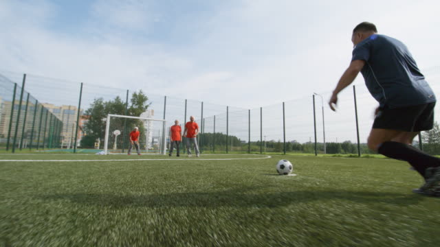 Mayores-futbolistas-jugando-juntos-al-aire-libre