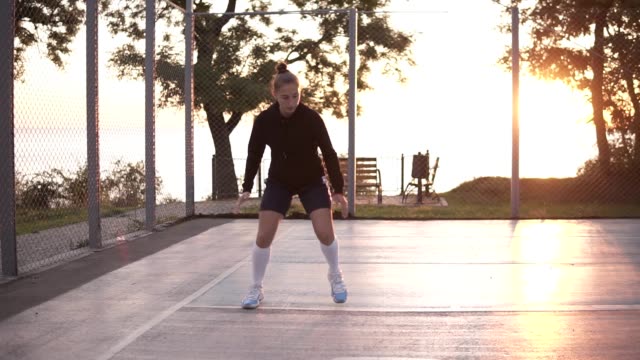 Largo-tiro-de-jugador-de-baloncesto-femenino-haciendo-piernas-botando-bueno-muy-rápidamente,-al-aire-libre-en-la-formación-en-la-corte-local