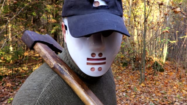 Man-in-Halloween-mask-with-an-ax-on-the-shoulder-in-close-up